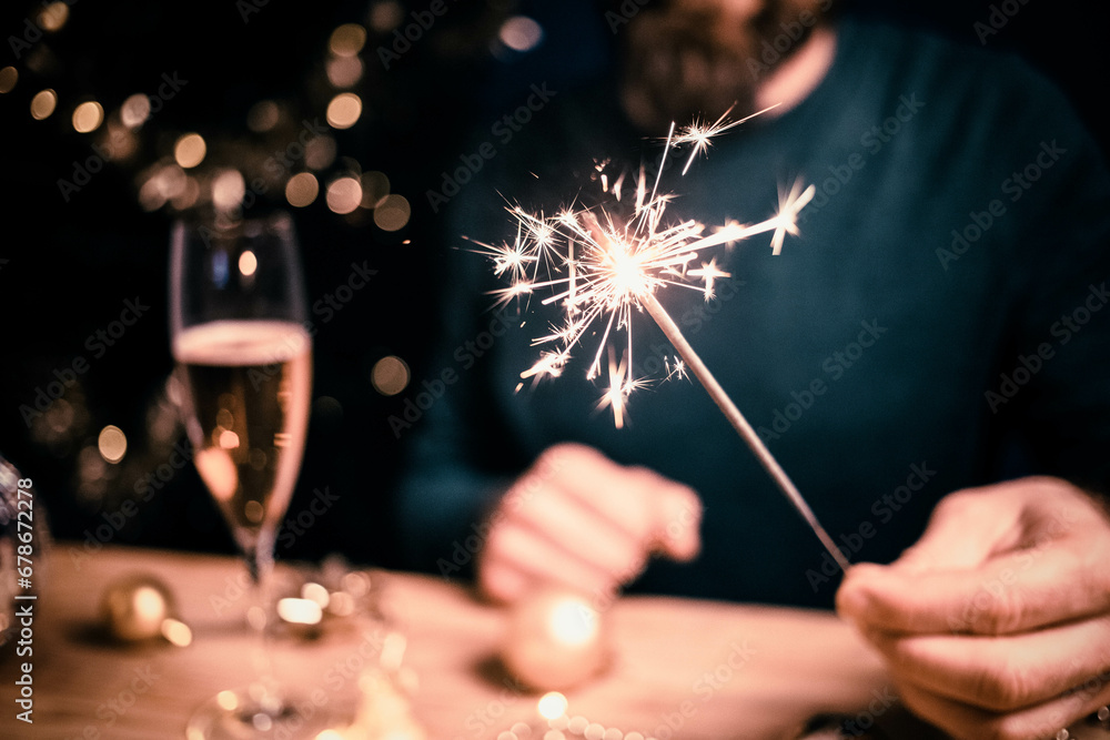 Wall mural man holding sparkles and champagne glass new year party