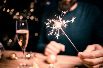 man holding sparkles and champagne glass New Year party - obrazy, fototapety, plakaty