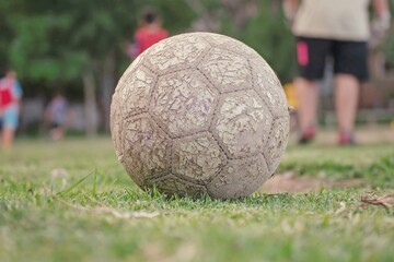 Pelota de futbol desgastada sobre el césped de la cancha © Maelia Rouch