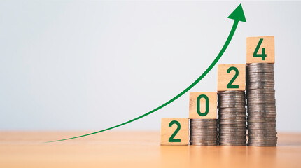 2024 year on coins stacking with up arrow for increasing money saving , business investment and...