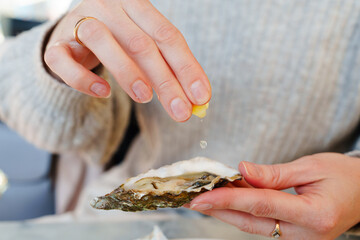 A young girl indulging in a luxurious outdoor picnic, meticulously arranged oysters and lemons...