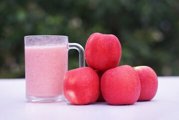 Pink apple fruits smoothie  in glass, outdoor background. Concept, healthy beverage for health....