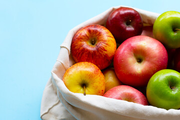 Variety of fresh apples on blue background.
