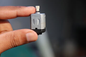 Toy DC motor or a small electric motor with single shaft with plastic gear attached to its shaft...