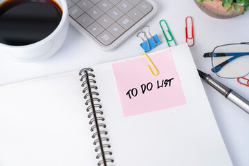 Office desk with pink sticker on notebook.
