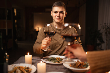 Cropped image of romantic young couple with glasses of red wine during date in restaurant or home, Love relationship celebration