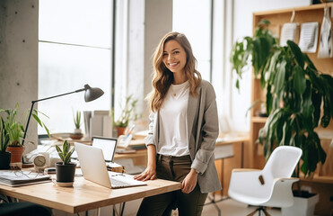 Happy female designer standing in office. Smiling woman designer work in the home office. Creative young girl working in her studio.