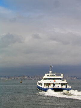 Seixal, Portugal. September 10, 2023: The Carnide, a modern jet ferry with catamaran hull from Transtejo leaves the Seixal Ferry Terminal to Lisbon on the horizon