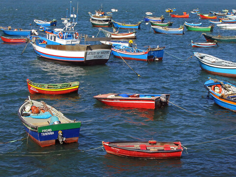 Trafaria, Portugal. March 29, 2023: Traditional small wooden fishing boats from the fishermen of Trafaria village anchored on the Tagus River estuary. Trafaria, Almada, Portugal