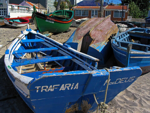 Trafaria, Portugal. March 29, 2023: Traditional small wooden fishing boats from the fishermen of Trafaria village on the Tagus River estuary. Trafaria, Almada, Portugal