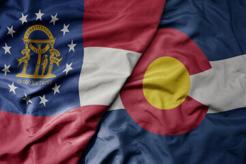 Fototapeta premium big waving colorful national flag of colorado state and flag of georgia state .