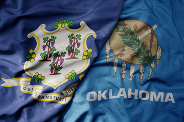 big waving colorful national flag of oklahoma state and flag of connecticut state .