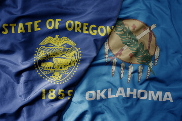 big waving colorful national flag of oklahoma state and flag of oregon state .