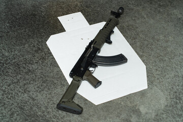 Tactical AK 47 rifle and target with bullet holes in the center.