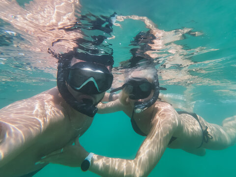 Underwater photo. A young couple is snorkeling underwater in Greece on the beach.
