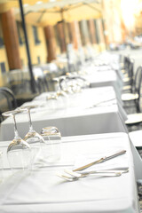 Elegant Restaurant tables in row terrace and rustic grey stone street background