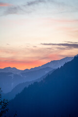 Pink blue hues of himalaya mountains fading off into fog showing the serene view from Manali Kullu...