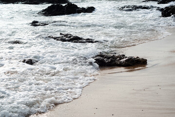 View of the sea with dark rocks.