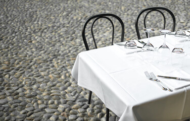 Elegant Restaurant table in terrace and rustic grey stone street background