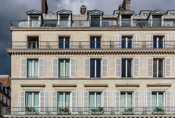 Sunny Elegance: Facade of a Building with Shutters in Paris
