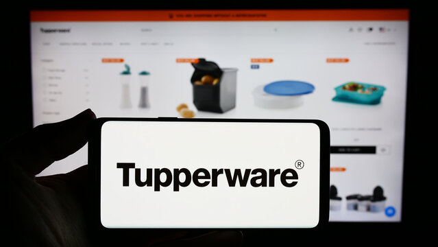 Stuttgart, Germany - 11-10-2023: Person holding smartphone with logo of US home product company Tupperware Brands Corporation in front of website. Focus on phone display.