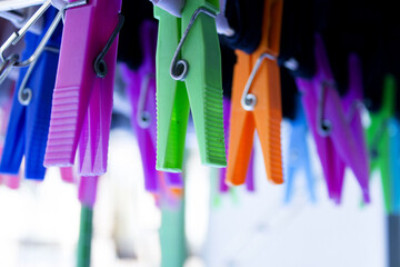 Clothespins holding clothes on clothesline. Various colors.