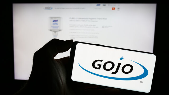 Stuttgart, Germany - 11-10-2023: Person holding mobile phone with logo of American consumer goods company Gojo Industries Inc. in front of web page. Focus on phone display.