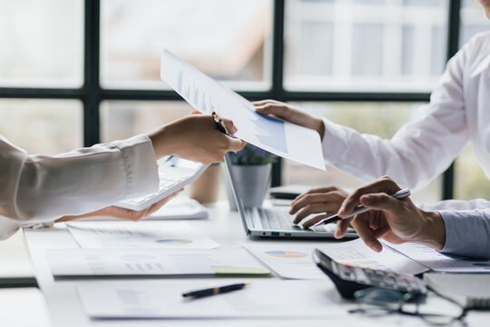 Meeting with financial advisors to analyze income and expenses charts for planning and managing business budgets.