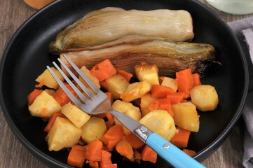 Repas de régime avec des endives et des légumes cuits vapeur servi dans une assiette avec une fourchette