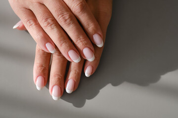 Hands with French manicure. New Perfect fingernails of woman.  Care for sensuality female hands....