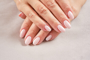 Hands with French manicure. New Perfect artificial fingernails of adult woman. Care for sensuality female hands. Shallow depth of field