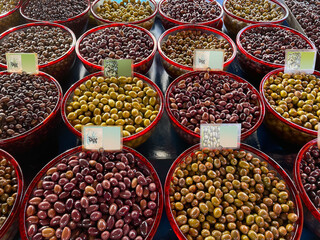 Olive stand in a farmer market on a street in Greece. Assortment of fresh olives in the Greek market with empty price tags. Mixed and A lot of Pitted Olives in the Bazaar of Athens. Healthy eating.