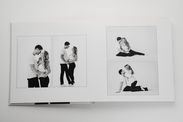 The pages of a photo book with a photo of a pregnant blonde and a man.  - obrazy, fototapety, plakaty