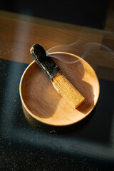 Burning and smoking palo santo on a wooden plate