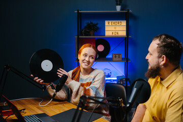 The artist presents his new album on the air of the radio station. Man and woman in home studio...