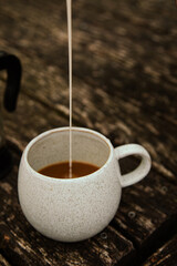 cup of coffee with pouring milk