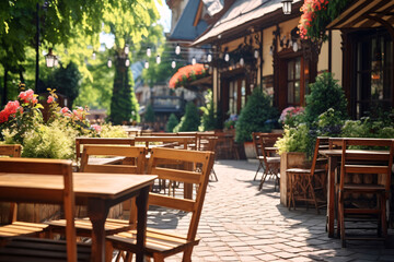 Fototapeta na wymiar Outdoor table of coffee cafe and restaurant. Summer terrace on city street. Empty outside tables and chairs of outdoor cafe on blur green garden. Cozy outdoor zone cafe and restaurant.