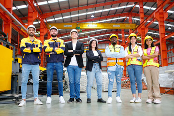 The engineering team and employees are happy to wear safety helmets. Smiling, happy working in the factory.