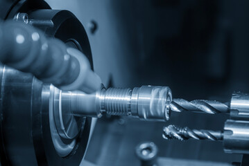 The  multi tasking CNC lathe machine swiss type drilling the brass fitting parts.