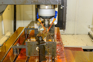 Close up scene the CNC milling machine cutting the  mold parts with oil coolant method.