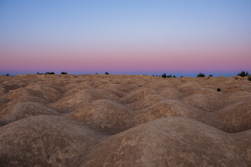 Fototapeta na wymiar Pink blue sunset in the desert with hills
