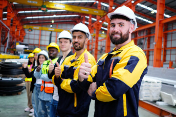 The engineering team and employees are happy to wear safety helmets. Smiling, happy working in the factory.