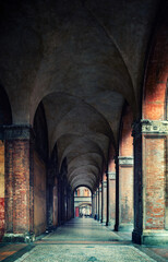 Arches and columns of ancient buildings. Bologna, Italy. Conceptual image on historical, religious...