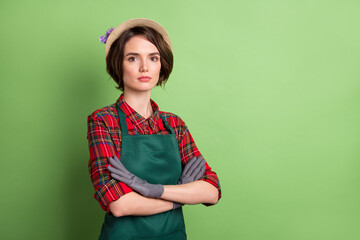 Profile portrait of half turned focused person crossed hands look camera isolated on green color background