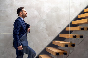 Handsome businessman walking up stairs