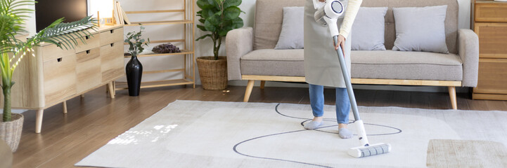 Beautiful woman vacuuming the floor and carpet in her living room, Big cleaning in the house, Removes germs, Housewife cleaning, Keeping her home clean, Domestic hygiene.