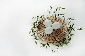 Easter white and brown eggs in a basket with flowers on a white background