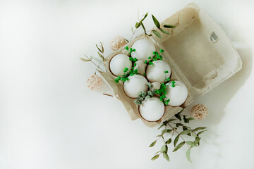 Fototapeta na wymiar Easter white and brown eggs in a basket with flowers on a white background
