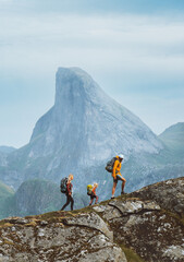 Family hiking in Norway mountains, active vacations with backpack outdoor. Parents and child traveling together healthy lifestyle adventure tour with mother, father and kid trekking in Lofoten islands - obrazy, fototapety, plakaty