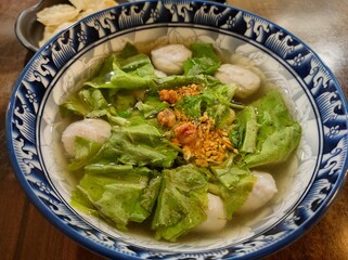 A bowl of fish balls and vegetables 